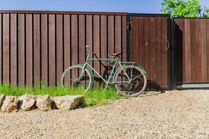 oude fiets geparkeerd bij een houten hek, countrycide landschap foto