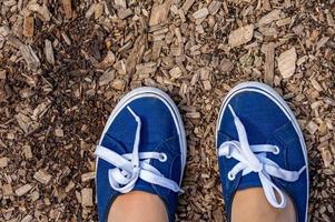 vrouw voeten in blauwe en witte sneakers. foto