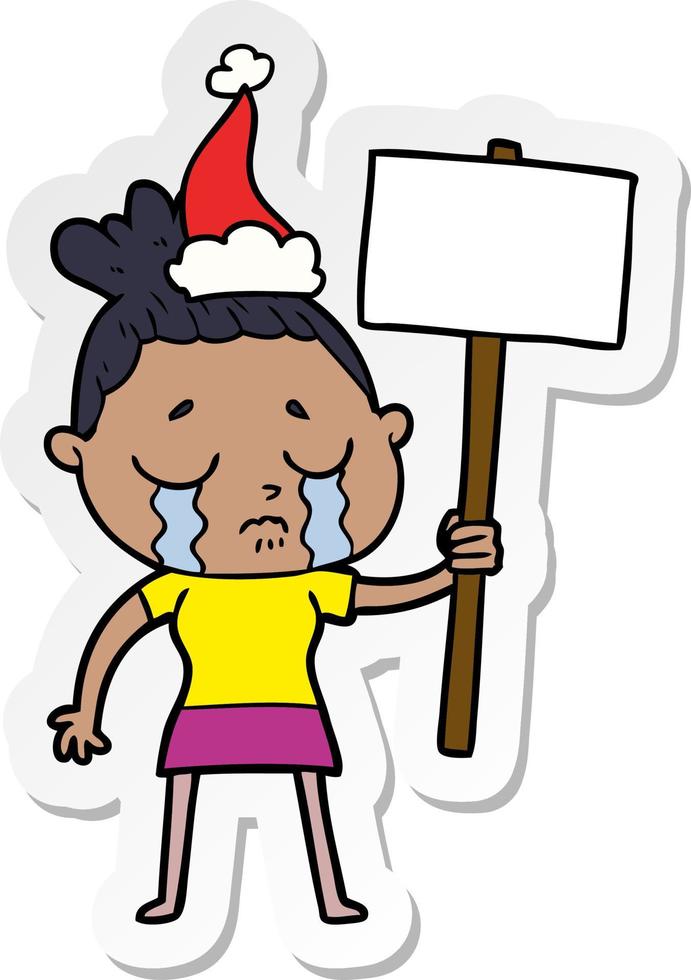 sticker cartoon van een huilende vrouw met protestbord met kerstmuts vector