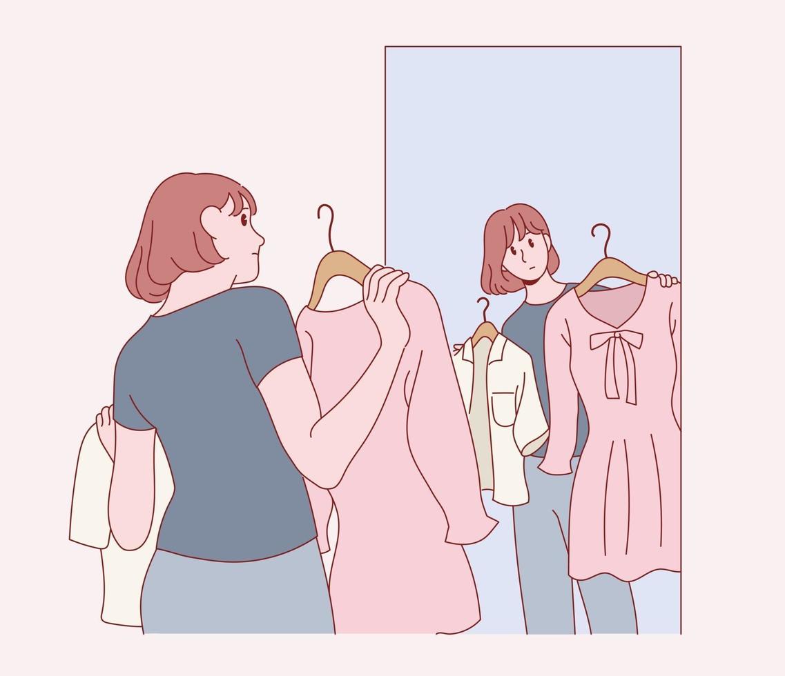 een vrouw houdt een jurk vast en kijkt in de spiegel. vector