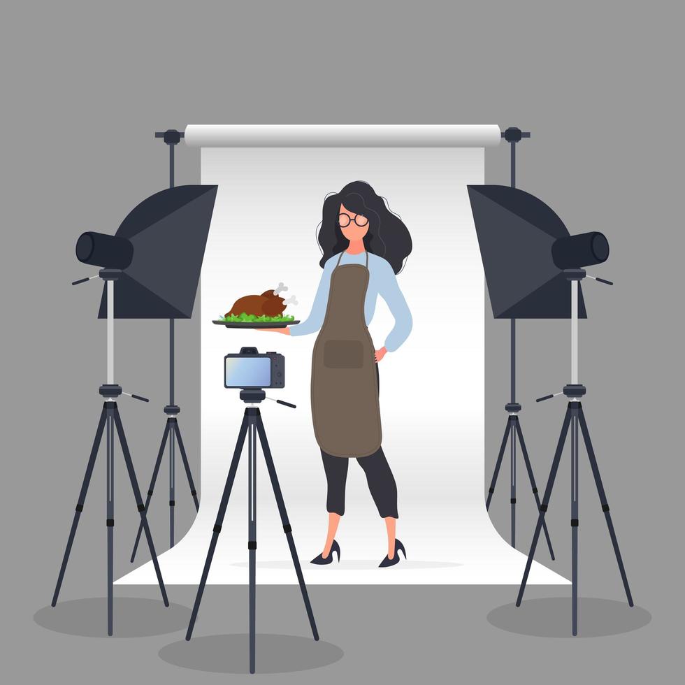 culinaire blogger. een vrouw in een keukenschort houdt een gebakken kip op een dienblad. camera op statief, softbox. het concept van een culinaire blog of vlog. vector. vector