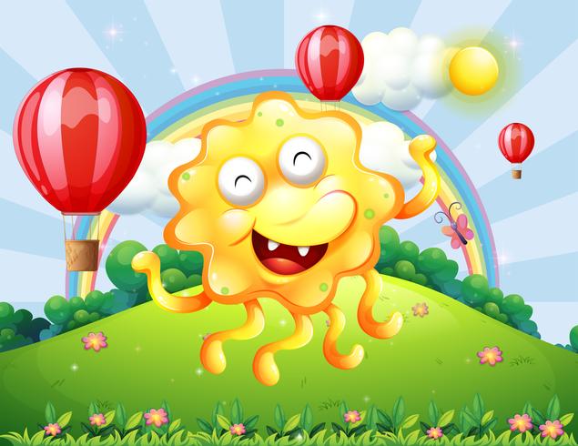 Een gelukkig geel monster op de heuveltop met een regenboog en zwevende ballonnen vector