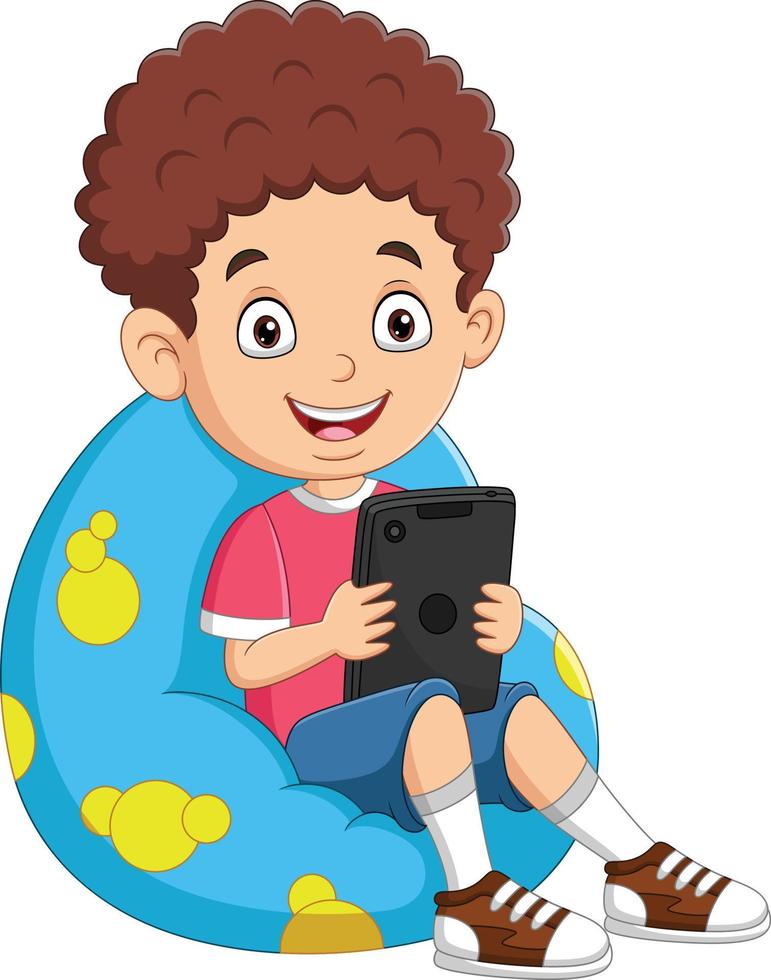 kleine jongen die tablet op groot kussen speelt vector