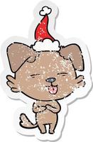verontruste sticker cartoon van een hond die zijn tong uitsteekt en een kerstmuts draagt vector