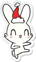 schattig sticker tekenfilm van een konijn dansen vervelend de kerstman hoed vector