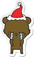 huilende sticker cartoon van een beer met een kerstmuts vector