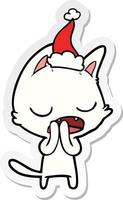 pratende kat sticker cartoon van een dragende kerstmuts vector