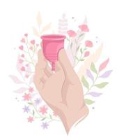 hand met een menstruatiecup op de achtergrond van een bloemen vector