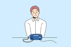 ongelukkig Mens zitten Bij bureau kijken Bij vaste telefoon telefoon aan het wachten voor iemand telefoongesprek. gefrustreerd vent in afwachting ring op zoek Bij met snoer telefoon. vector illustratie.