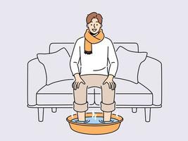 glimlachen Mens in sjaal zitten Aan sofa Bij huis genieten voeten in heet water. gelukkig mannetje lijden van verkoudheid of griep Doen procedures voor snel herstel. gezondheidszorg. vector illustratie.