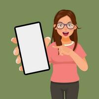 verrast jong vrouw met Open mond richten vinger naar slim telefoon met blanco scherm vector