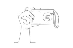 een hand- Holding een digitaal camera vector