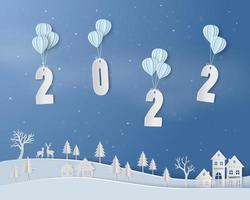 gelukkig nieuwjaar 2022 met ballon zwevend boven het platteland op papier kunst achtergrond vector