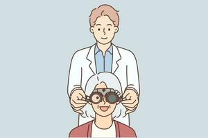 Mens optometrist zetten Aan oogheelkundig bril Aan grijs haar ouderen vrouw geduldig gedurende visie behandeling. oud vrouw glimlachen Bij oogarts afspraak en verheugt Bij verbetering in visie vector