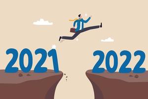 jaar 2022 hoop, nieuwjaarsresolutie of succeskans, verandering naar nieuwe zakelijke mooie toekomst, overwin bedrijfsmoeilijkhedenconcept, ambitieuze zakenman sprong over jaarkloof van 2021 tot 2022.