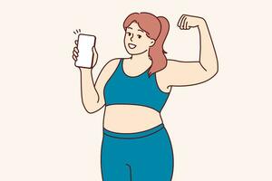mollig vrouw in geschiktheid kleren demonstreert biceps en moedigt aan gebruik mobiel telefoon met sport- apps vector