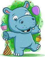 gelukkig nijlpaard viert het feest met de ballon en cake vector