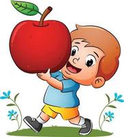 de jongen houdt de rode rijpe appel vast met de vrolijke uitdrukking vector