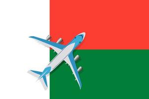 vectorillustratie van een passagiersvliegtuig dat over de vlag van Madagaskar vliegt. concept van toerisme en reizen vector