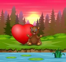 een babybeer zittend met rood hart in de natuur vector