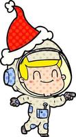 vrolijke stripboekstijlillustratie van een astronaut die een kerstmuts draagt vector