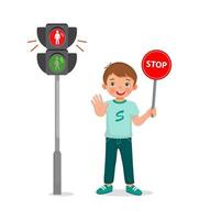 schattige kleine jongen met stopbord in de buurt van voetgangersverkeerslicht met rood indicatielampje aan vector