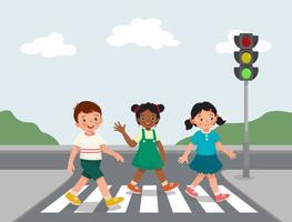 schattige gelukkige kinderen lopen overstekende weg in de buurt van verkeerslicht op zebrapad