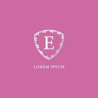 e eerste logo ontwerp briefsjabloon geïsoleerd op roze kleur achtergrond. luxe zilveren decoratieve bloemen schild illustratie. geschikt voor verzekeringen, mode en beautyproducten. vector