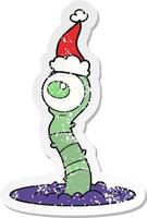 verontruste sticker cartoon van een buitenaards moerasmonster met een kerstmuts vector