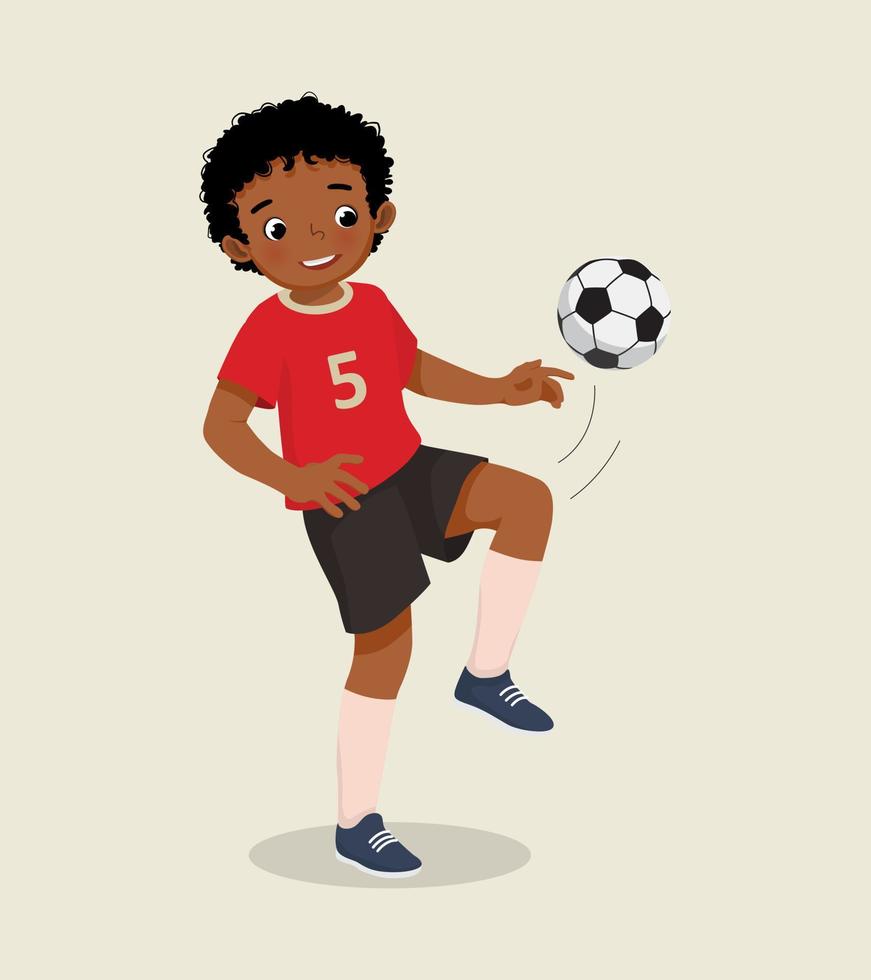 süßer kleiner afrikanischer junge, der fußball spielt und übt, den fußball mit seinem knie zu treten vektor
