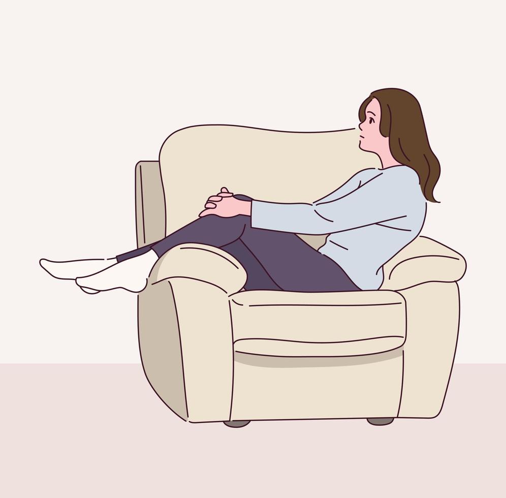 en kvinna sitter i soffan i sidled. vektor