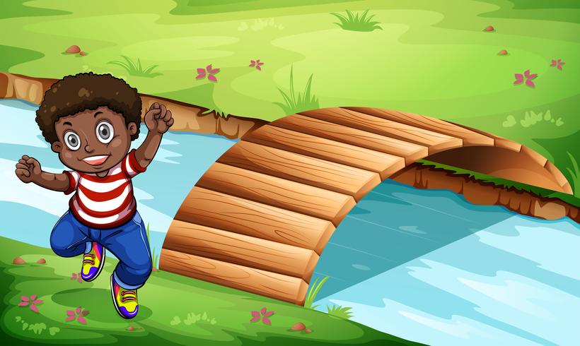 Ein glückliches schwarzes Kind nahe der Holzbrücke vektor