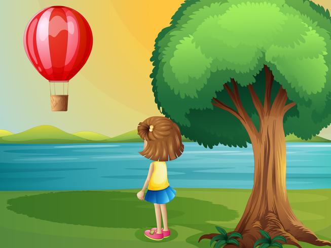 Ein Mädchen, das den Heißluftballon am Flussufer aufpasst vektor