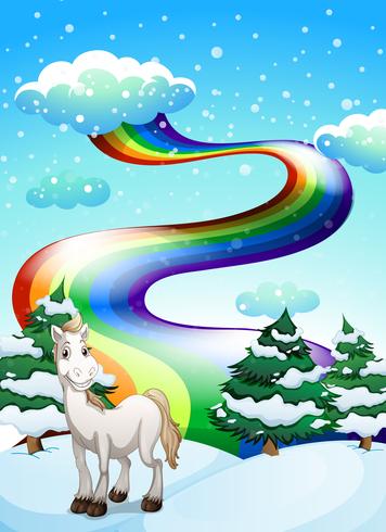 En häst i ett snöigt område och en regnbåge i himlen vektor