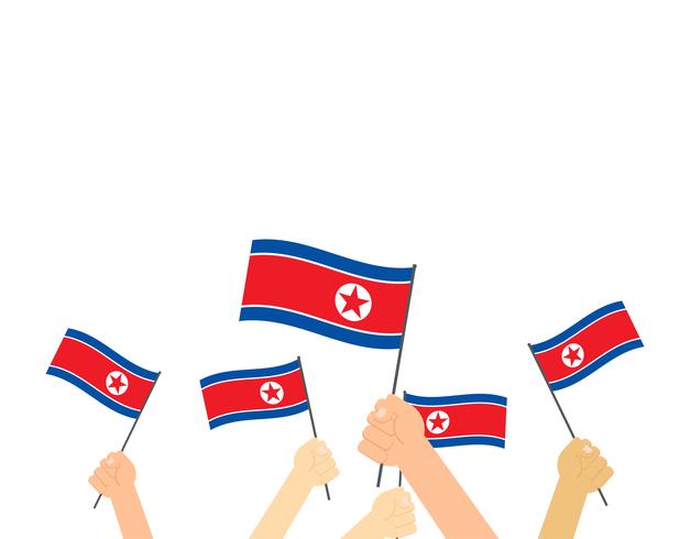 Hand som håller Nordkorea flaggor isolerad på vit bakgrund vektor