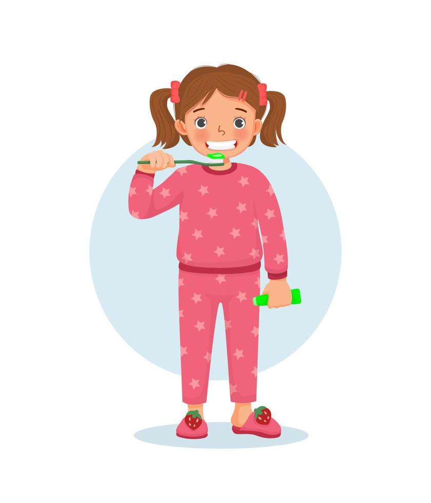 söt liten flicka i pyjamas borstar tänderna med tandkräm gör dagliga rutinmässiga hygienaktiviteter i badrummet vektor
