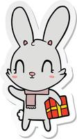 Aufkleber eines niedlichen Cartoon-Kaninchens mit Weihnachtsgeschenk vektor