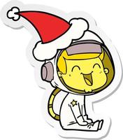 Fröhlicher Aufkleber-Cartoon eines Astronauten mit Weihnachtsmütze vektor