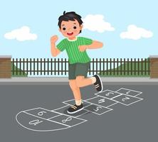Fröhlicher kleiner Junge, der draußen auf der Spielplatzstraße im Park mit Kreide gezeichnete Hopse spielt vektor