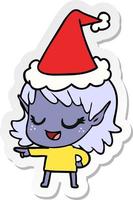 Fröhlicher Aufkleber-Cartoon eines Elfenmädchens, das mit Weihnachtsmütze zeigt vektor