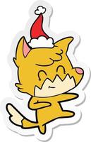 klistermärke tecknad serie av en vänlig räv bär santa hatt vektor