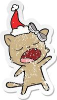 bedrövad klistermärke tecknad serie av en sång katt bär santa hatt vektor