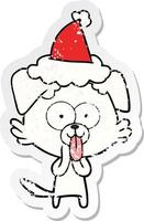 Distressed Sticker Cartoon eines Hundes mit herausgestreckter Zunge und Weihnachtsmütze vektor