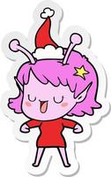 glücklicher Alien-Mädchen-Aufkleber-Cartoon einer tragenden Weihnachtsmannmütze vektor
