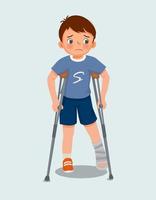 söt liten pojke har bruten fraktur ben med bandage kasta på ben gående använder sig av kryckor vektor