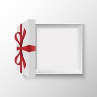 Draufsicht auf geöffnete Geschenkbox mit roter Schleife
