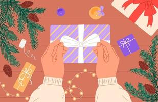 eine person bereitet ein weihnachtsgeschenk vor, bindet eine schleife an einer schachtel vektor