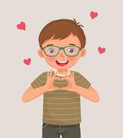 süßer kleiner junge, der herzformzeichen mit handgestensymbol der liebe für valentinstagfeiern zeigt vektor