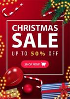 Weihnachtsverkauf, bis zu 50 Rabatt, rotes vertikales Rabattbanner mit Geschenken, Zuckerstangen, Weihnachtsbaumzweigen und Ballon auf der Oberfläche, Draufsicht vektor