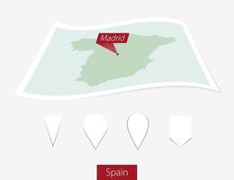 böjd papper Karta av Spanien med huvudstad madrid på grå bakgrund. fyra annorlunda Karta stift uppsättning. vektor